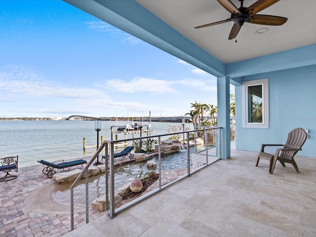 balcony with ceiling fan and a water view