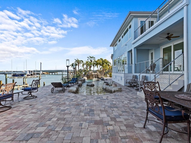 view of patio / terrace with ceiling fan and a water view