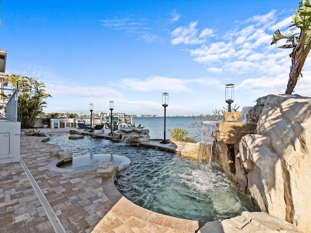 view of patio featuring pool water feature and a water view