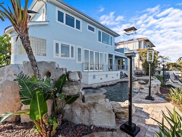 rear view of house featuring a balcony and a patio