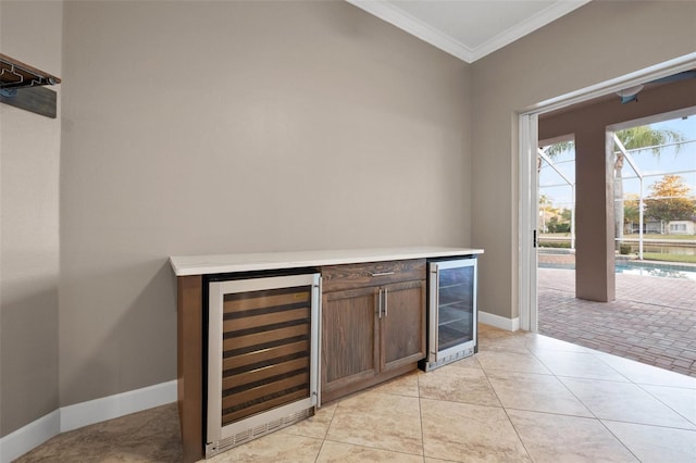 bar with ornamental molding, light tile patterned flooring, and wine cooler