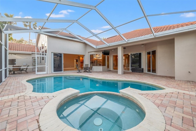 view of swimming pool with an in ground hot tub, a lanai, and a patio