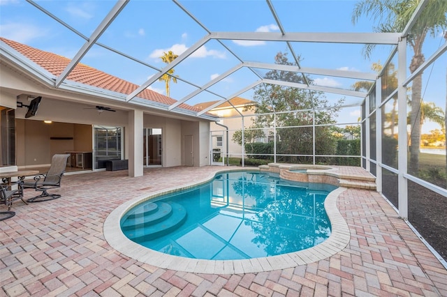 view of swimming pool with an in ground hot tub, a lanai, ceiling fan, and a patio area