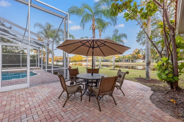 view of patio / terrace featuring a water view and glass enclosure