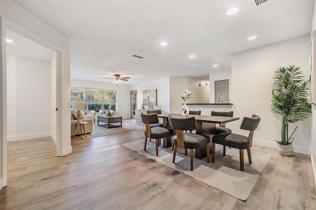 dining room with ceiling fan and light hardwood / wood-style floors