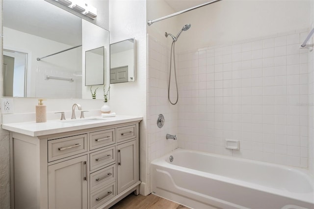 bathroom featuring vanity, wood-type flooring, and tiled shower / bath