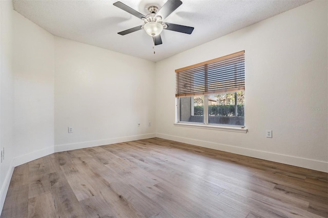 unfurnished room with ceiling fan, a textured ceiling, and light wood-type flooring