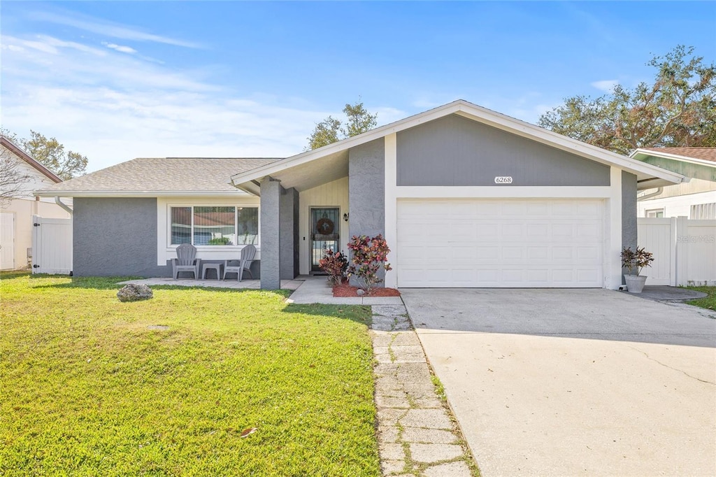 single story home featuring a garage and a front lawn