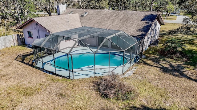 view of pool featuring a lanai, a lawn, and central air condition unit