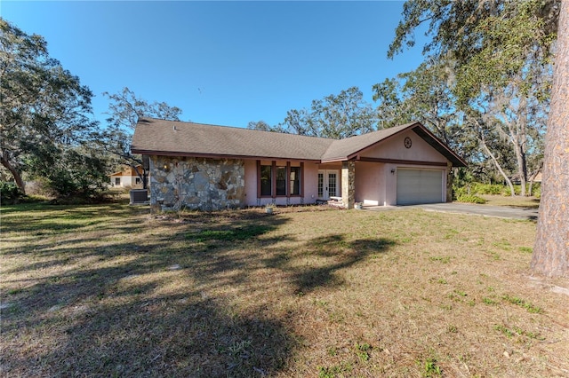 ranch-style home featuring central AC unit, a garage, and a front lawn