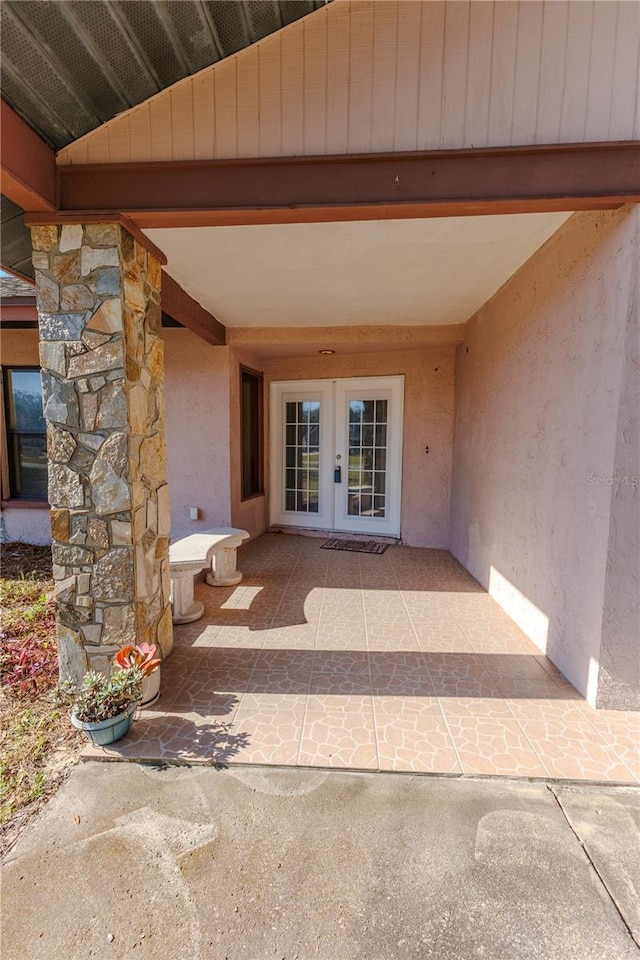 property entrance featuring a patio and french doors