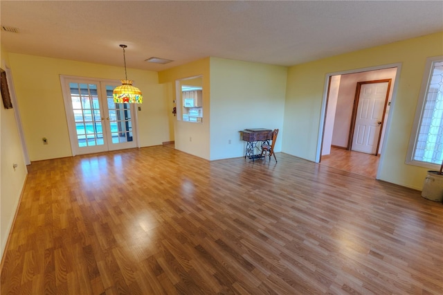 unfurnished room featuring french doors, wood-type flooring, and a textured ceiling