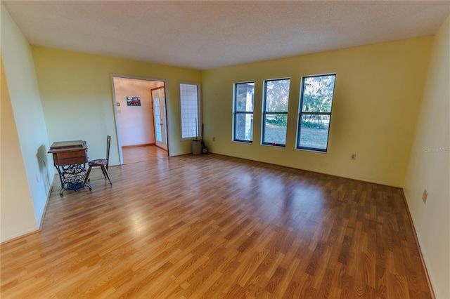 unfurnished room featuring wood-type flooring and a textured ceiling