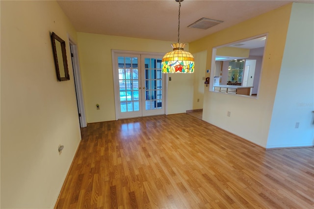 unfurnished dining area with light wood-type flooring and french doors