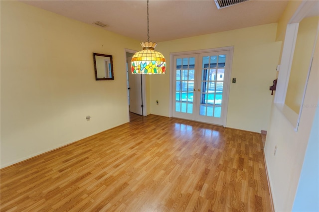 unfurnished dining area with light wood-type flooring and french doors