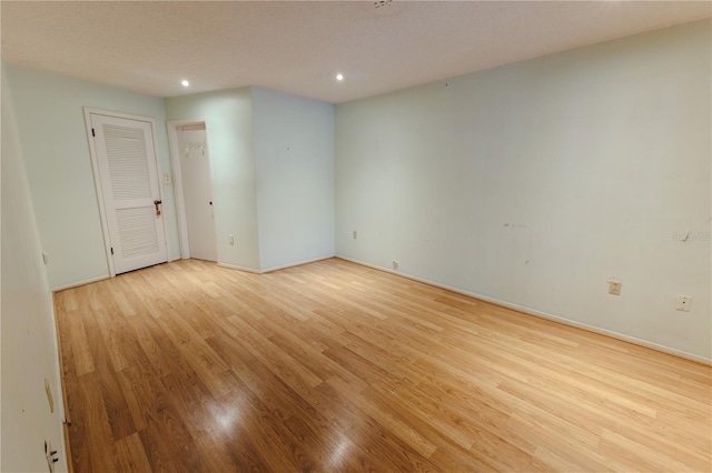 unfurnished room featuring light hardwood / wood-style floors and a textured ceiling