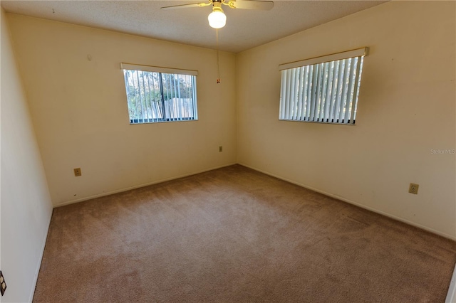 spare room with light colored carpet and ceiling fan