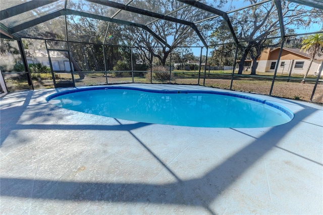 view of swimming pool with a lanai and a lawn