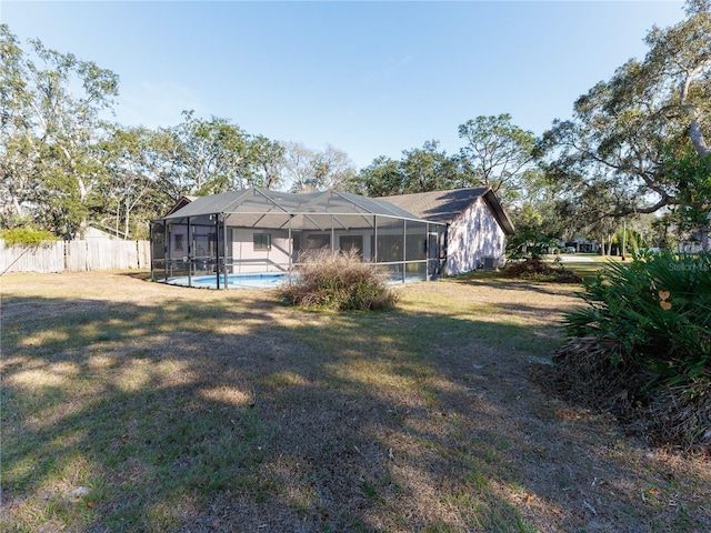 view of yard featuring a fenced in pool and glass enclosure