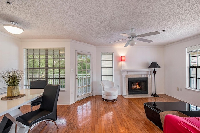 living room featuring hardwood / wood-style flooring, ornamental molding, and a textured ceiling