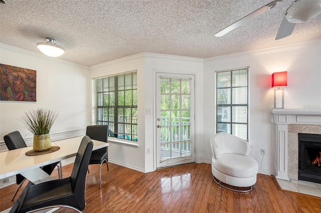 interior space with crown molding, ceiling fan, wood-type flooring, and a fireplace