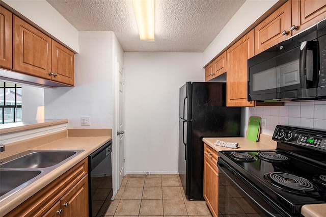 kitchen featuring light tile patterned flooring, sink, decorative backsplash, black appliances, and a textured ceiling