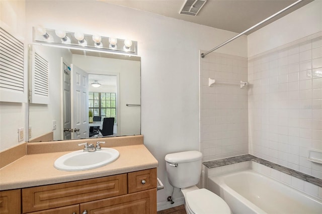 full bathroom with vanity, tiled shower / bath, and toilet