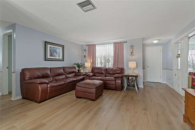 living room with a healthy amount of sunlight and light hardwood / wood-style flooring