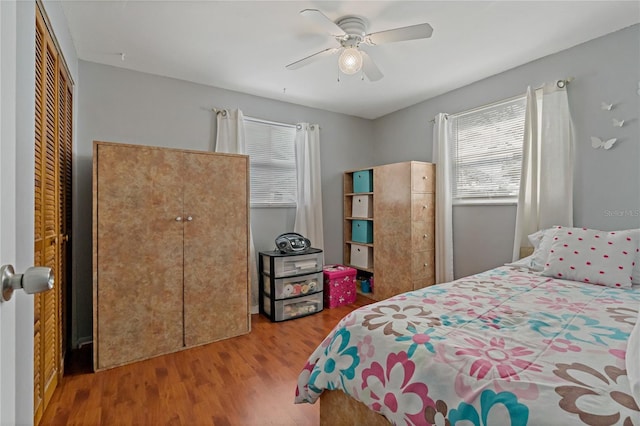 bedroom with wood-type flooring, a closet, and ceiling fan