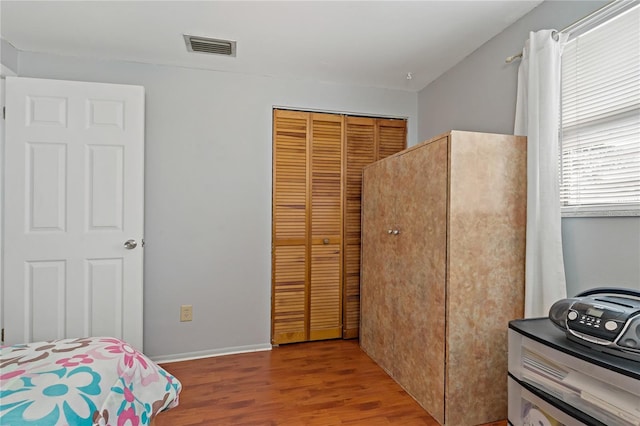 bedroom with light hardwood / wood-style floors and a closet