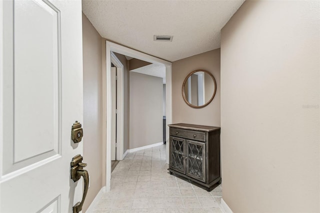 corridor featuring a textured ceiling