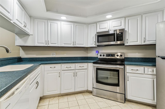 kitchen featuring white cabinetry, sink, a raised ceiling, and appliances with stainless steel finishes