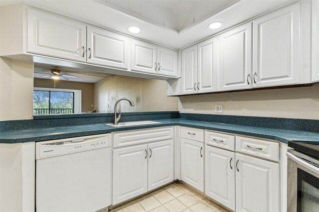 kitchen featuring white dishwasher, sink, light tile patterned floors, and white cabinets