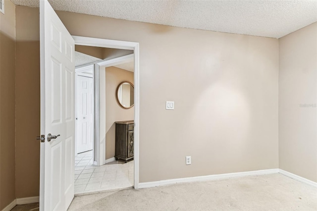 carpeted spare room featuring a textured ceiling