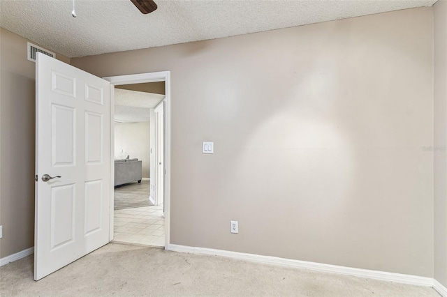 carpeted spare room with ceiling fan and a textured ceiling