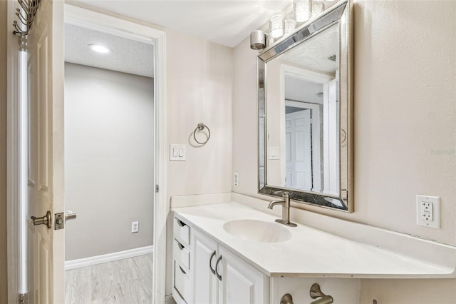 bathroom with vanity, wood-type flooring, and a textured ceiling