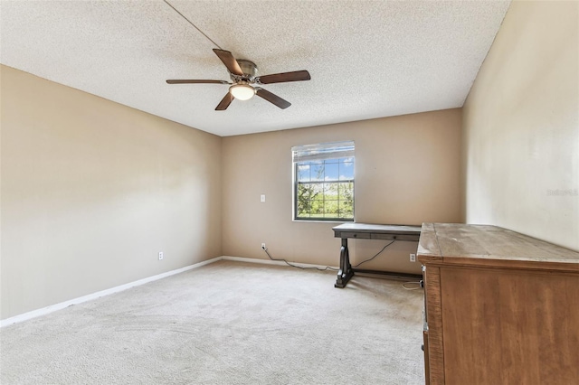 carpeted spare room featuring ceiling fan and a textured ceiling