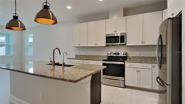 kitchen with appliances with stainless steel finishes, sink, dark stone counters, and decorative light fixtures