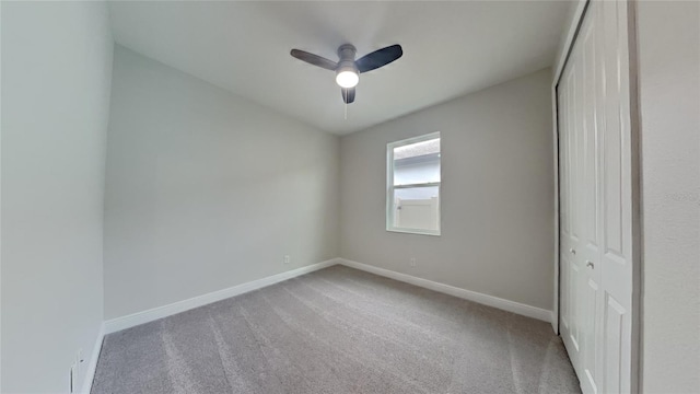 empty room featuring ceiling fan and light carpet