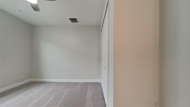 carpeted spare room featuring ceiling fan