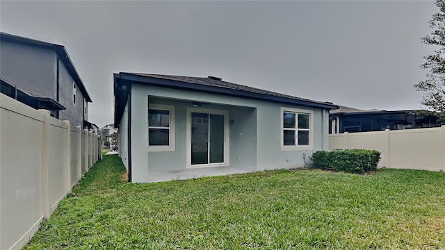 rear view of house featuring a yard