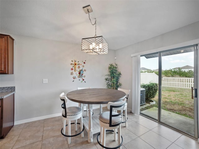 dining area with an inviting chandelier and light tile patterned flooring