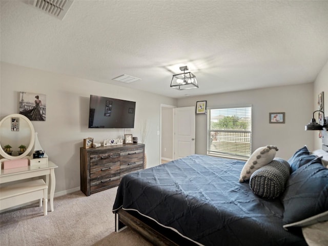 bedroom featuring light carpet and a textured ceiling