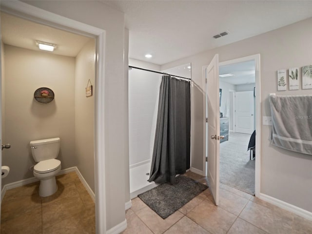 bathroom with tile patterned flooring, a shower with curtain, and toilet