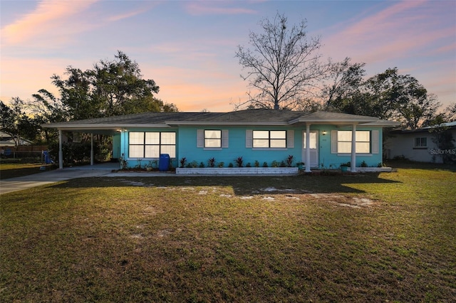 ranch-style home featuring a yard and a carport