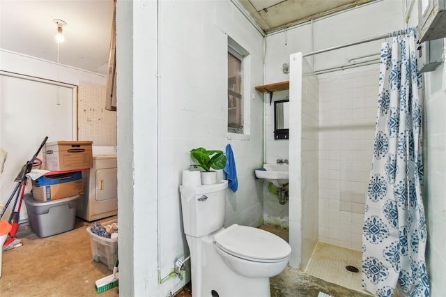 bathroom with washer / clothes dryer, toilet, concrete floors, and a shower with shower curtain