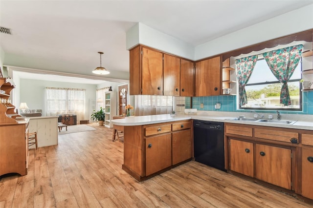 kitchen with sink, dishwasher, decorative light fixtures, kitchen peninsula, and light wood-type flooring