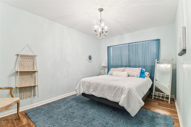 bedroom with dark wood-type flooring and a chandelier