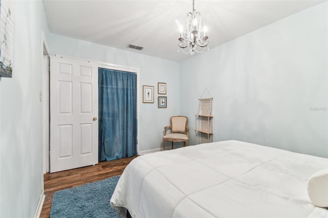 bedroom featuring dark hardwood / wood-style floors and a chandelier