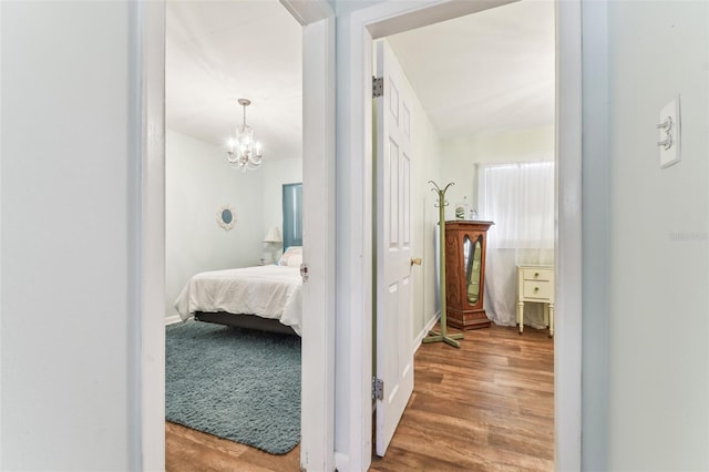 hall featuring hardwood / wood-style flooring and a notable chandelier